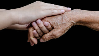Letzte Hilfe - junge Hände umfassen alte Hände