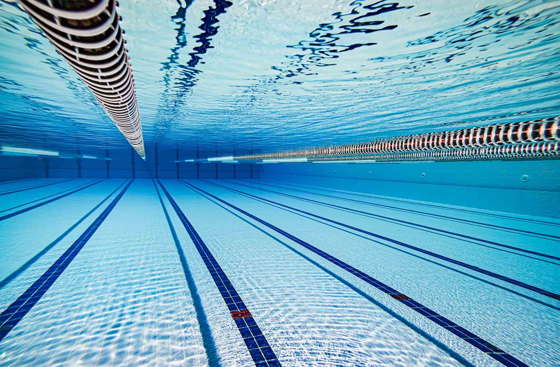 Blick auf ein Schwimmbecken mit mehreren Bahnen im Hallenbad